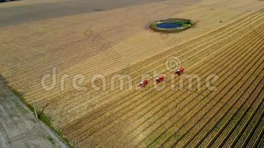 高空俯视图.. 三台<strong>大红</strong>联合收割机在初秋收割玉米田。 过滤拖拉机